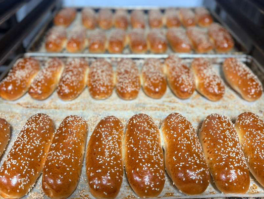 Baked kosher hotdog buns on a baking tray inside an oven